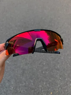Ember sunglasses held up outdoors against grey pavement