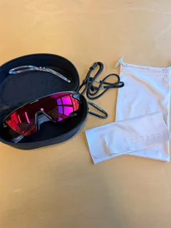 Ember sunglasses in their case beside the safety strap and soft pouch
